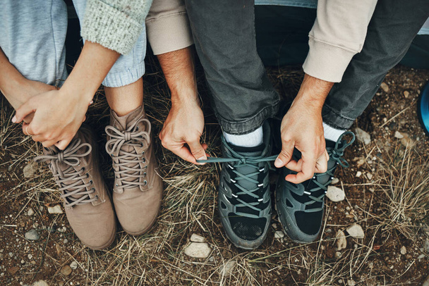 Shoes, hands tie lace and hiking, people outdoor in nature for travel with adventure top view. Boots, friends camping with start or prepare for walk, trekking and journey with health and fitness. - Photo, Image