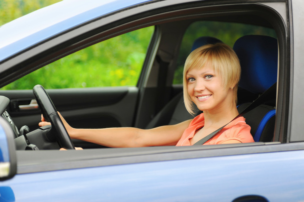lachende jonge vrouw in de auto - Foto, afbeelding