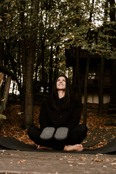 Girl posing and holding hands on Sadhu boards in autumn in the forest. Yoga and nailing concept - Photo, Image