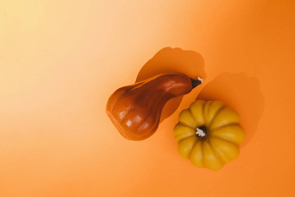 Voskově žluté a červené svíčky ve formě dýně na oranžovém bezešvém pozadí. Podzim, Halloween. Horní pohled - Fotografie, Obrázek