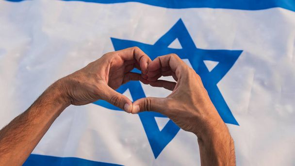 Hand in heart shape on Israel flag. - Photo, Image