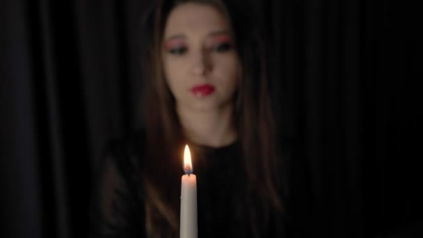 junges Vampirmädchen bläst brennende Kerze aus Konzept der Halloween-Feier Fokus auf das Gesicht der Mädchen Hochwertiges 4k Filmmaterial - Filmmaterial, Video