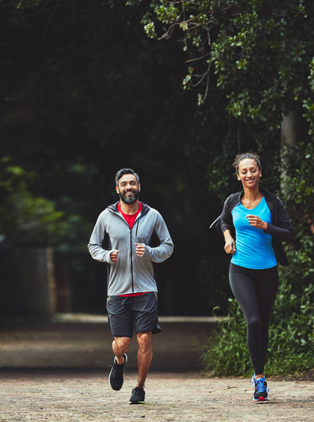 Paar, Laufen im Park für Fitness und Gesundheit im Freien, Unterstützung und Training für Marathon mit Cardio. Läufer, Athlet und Sport mit Menschen in der Natur, Herausforderung und Bewegung mit Workout für Rennen. - Foto, Bild