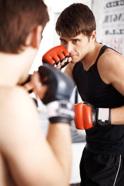 Μάχη και πυγμαχία στην εκπαίδευση πολεμικών τεχνών με συνεργάτη πυγμαχίας για τεχνικές αυτοάμυνας στο Ντότζο. Άνδρας, αθλητής ή πυγμάχος έτοιμος για μάχη, καράτε ή MMA σε jujitsu ή αγώνα σε ρινγκ. - Φωτογραφία, εικόνα