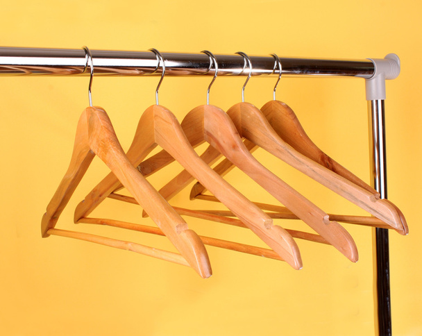 Wooden coat hangers on a clothes rail - Фото, изображение