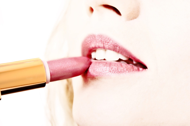 Beautiful young girl making up her lips with lipstick - Valokuva, kuva