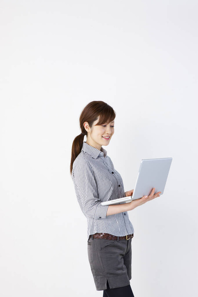 young  asian woman with laptop in office - Photo, image