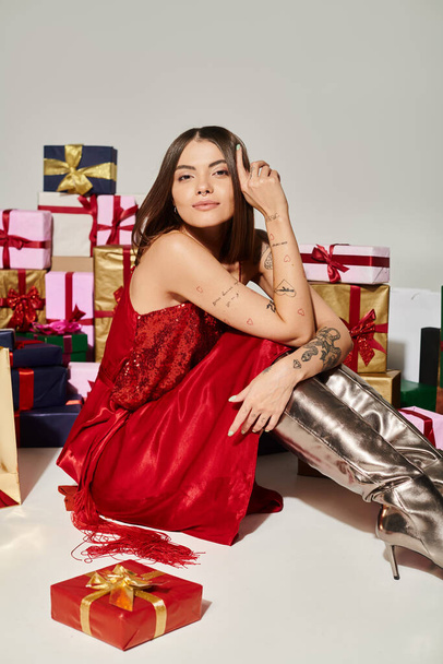 joyous lady sitting on floor surrounded by presents and looking at camera, holiday gifts concept - Photo, Image