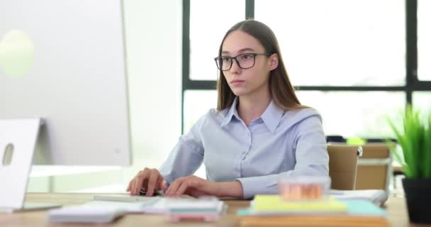 Шокована молода бізнес-леді читає погані новини на комп'ютері, сидячи на робочому місці в офісі. Сумний менеджер розчарований анотацією, отриманою або побаченою в Інтернеті - Кадри, відео