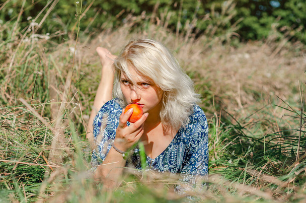 Mulher loira bonito deitado na grama comendo maçã no piquenique - Foto, Imagem