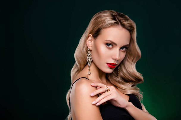 Closeup portrait of young beautiful blonde female model presenting golden earrings and ring with diamonds studio photo. - Photo, Image