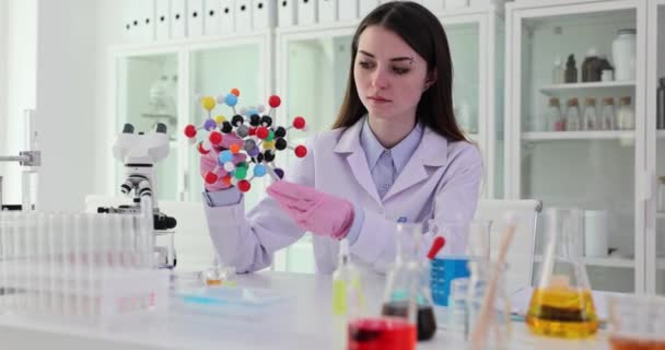 Estudiante científico sosteniendo modelo de estructura molecular en laboratorio. Concepto de educación científica e investigación química - Metraje, vídeo