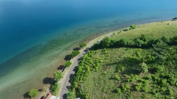 Letecký pohled na oceánské pobřeží se silnicí u pobřeží v Sumbawě - Záběry, video