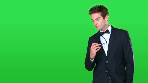 Man in tuxedo, glasses and thinking on green screen, black tie fashion, future and inspiration on studio background. Classy style, formal clothes and mockup space, thoughtful and ideas with vision. - Footage, Video