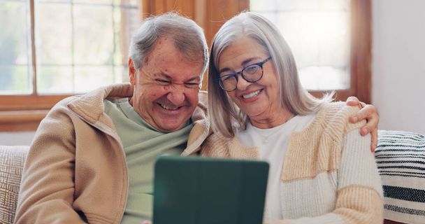 Tablet, Gespräch und Seniorenpaar auf dem Sofa im Wohnzimmer beim Netzwerken in den sozialen Medien. Digitale Technologie, Bindung und ältere Menschen im Ruhestand scrollen auf mobilen Apps oder dem Internet zu Hause. - Foto, Bild