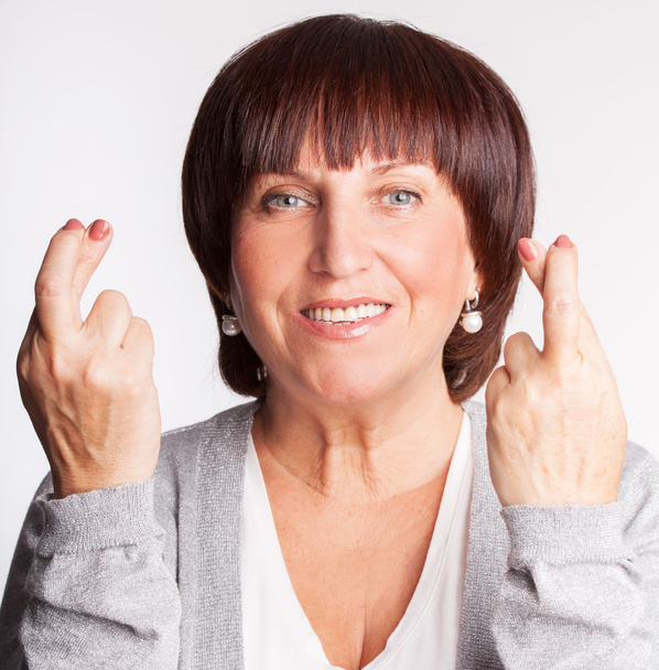 Mulher madura com dedos cruzados
 - Foto, Imagem