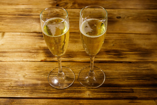 Kaksi lasillista samppanjaa puupöydällä - Valokuva, kuva