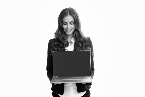 Retrato de una joven empresaria usando un ordenador portátil aislado sobre un fondo gris. Las mujeres de negocios en traje excitado algo en la pantalla del ordenador portátil. Retrato de una dama de negocios sosteniendo un cuaderno - Foto, imagen