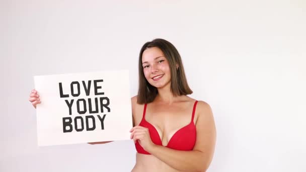 Porträt einer selbstverliebten Frau plus Größe in roter Unterwäsche auf weißem Hintergrund, Körperliebe. - Filmmaterial, Video