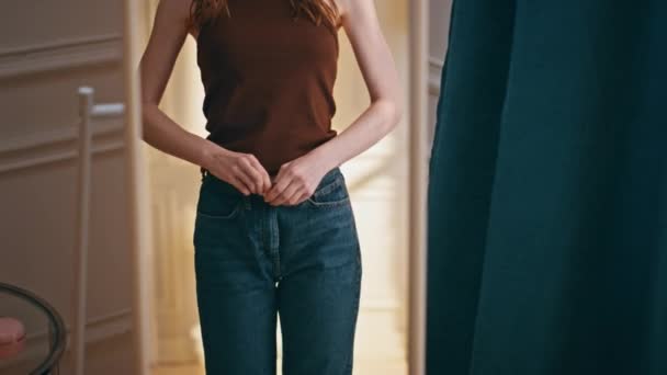 Reflexão feminina verificando o progresso da perda de peso. Mulher sorridente tentando jeans grandes analisando o tamanho da cintura em casa. Modelo elegante alegre verificando os resultados perfeitos da dieta. Satisfeito menina feliz olhando espelho. - Filmagem, Vídeo
