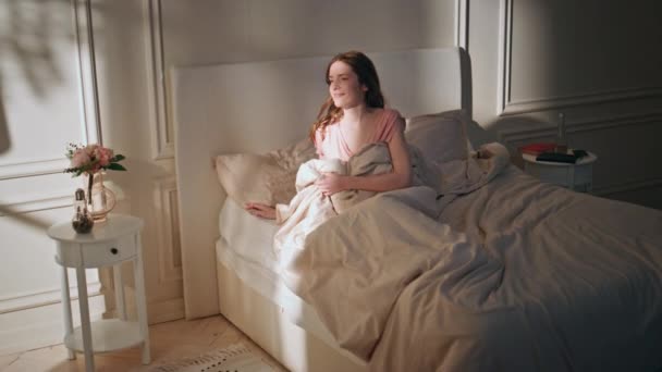 Smiling girl lying sunlight in cozy home bed. Closeup happy woman open curtains enjoying morning atmosphere. Attractive excited model wake up looking window. Cheerful female leaving start new day. - Footage, Video