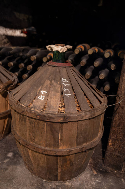 Proceso de envejecimiento del alcohol de coñac en barricas viejas de roble francés oscuro en bodega en la destilería, región de vino blanco de Cognac, Charente, Segonzac, Grand Champagne, Francia - Foto, Imagen
