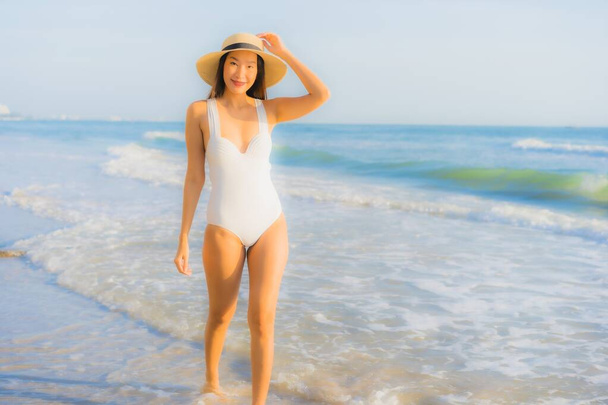Güzel bir Asyalı kadın portresi. Okyanus sahillerinde mutlu bir gülümseme ve tatil için mavi bir gökyüzü. - Fotoğraf, Görsel