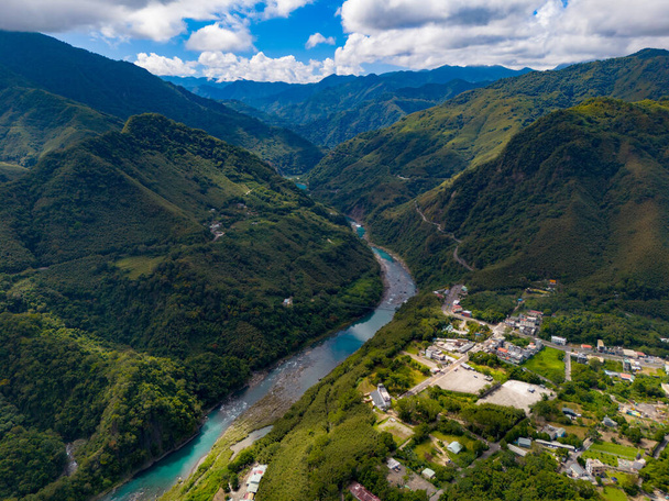 De azuurblauwe rivier weerspiegelt de lucht terwijl hij door de vallei stroomt. - Foto, afbeelding