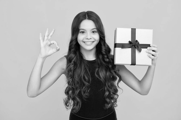 Child with gift present box on isolated background. Presents for birthday, Valentines day, New Year or Christmas. Happy girl face, positive and smiling emotions - Foto, Imagem