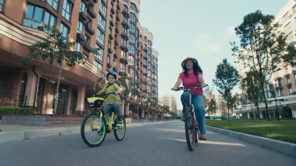 Pedałowanie przez Metropolis: serdeczna wyprawa rowerowa matka-syn w mieście. Wysokiej jakości materiał 4k - Materiał filmowy, wideo