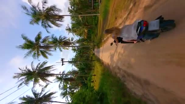 Вертикальне відео. Вид з повітря на жінку, що катається на скутері на тропічному острові. - Кадри, відео