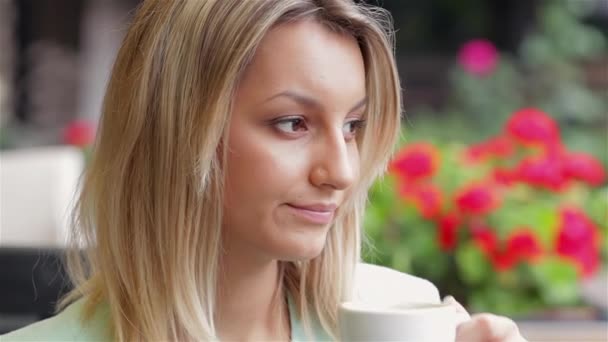 カフェの外でコーヒーを飲む若い女性。ビジネス女性 - 映像、動画