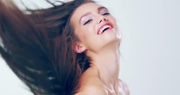 Face, hair care and woman with a smile, volume and texture on a white studio background. Portrait, happy person and model with aesthetic, luxury and grooming with happiness, confidence and treatment. - Footage, Video