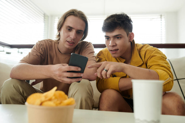 Genç erkekler akıllı telefondan yeni uygulamaları tartışıyor - Fotoğraf, Görsel
