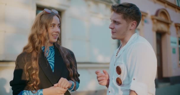 Гетеросексуальна пара розмовляє один з одним, будуючи в місті під час відпустки - Кадри, відео