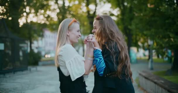 Szczęśliwy blondynka młode kobiety trzymając się za ręce i taniec podczas korzystania w ogrodzie w weekend - Materiał filmowy, wideo