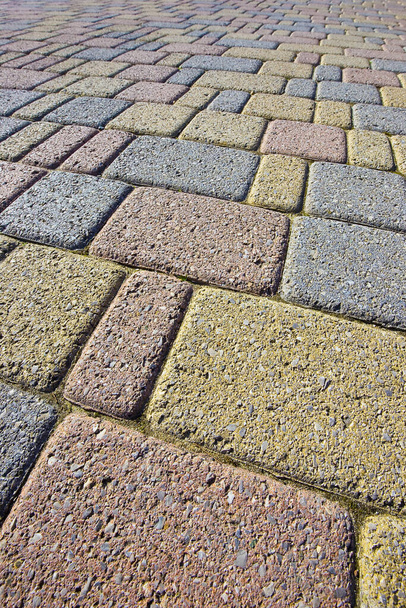 Цветные бетонные самозапирающиеся напольные блоки, собранные на подложке из песка - тип напольных покрытий, проницаемых для дождевой воды, как того требуют строительные законы - Фото, изображение
