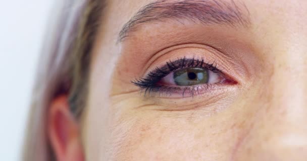 Blaues Auge, Sehvermögen und gesundes Sehen einer Frau für Kontaktlinsen und Augenoptik Bewusstsein. Nahaufnahme Zoom eines Mädchens mit einer schönen und natürlichen Irisfarbe und Wimpern blinkt durch Studio-Hintergrund. - Filmmaterial, Video