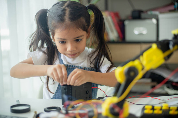 Концепция образования STEM. Азиатская юная девушка изучает дизайн робота. - Фото, изображение