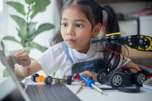 STEM-onderwijsconcept. Aziatisch jong meisje leren robot ontwerp. - Foto, afbeelding