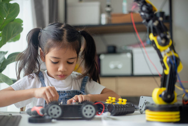 STEM εκπαίδευση έννοια. Ασιατική νεαρή κοπέλα μάθηση σχεδιασμό ρομπότ. - Φωτογραφία, εικόνα