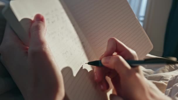 Mãos femininas escrevendo diário à luz do sol closeup. Mulher fazendo anotações no horário do dia de fim de semana de planejamento da cama da manhã. Menina não reconhecida compartilhar pensamentos ideias criativas no caderno. Conceito de lazer estilo de vida - Filmagem, Vídeo