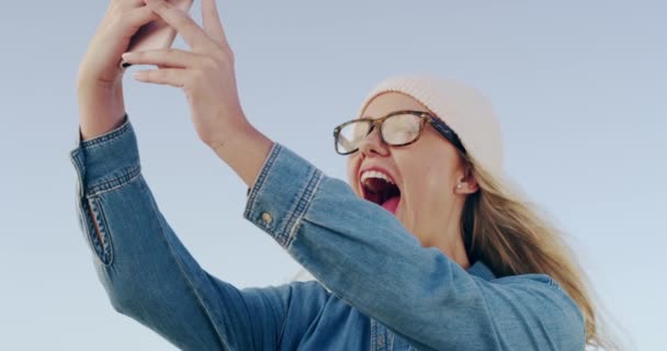 Woman, selfie and outdoor with glasses, happy and excited with post, web blog and wind by sky background. Gen Z girl, student and smile with memory, photography and profile picture on social network. - Footage, Video