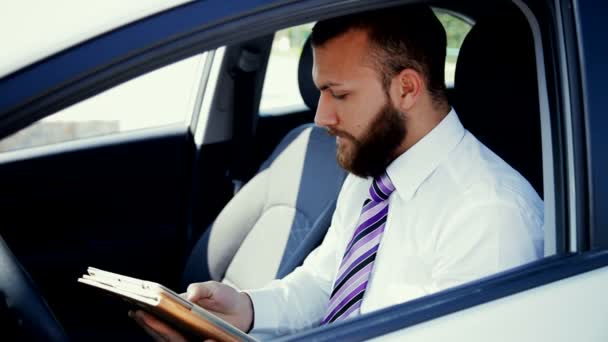 Homem de negócios legal está sentado no carro
 - Filmagem, Vídeo
