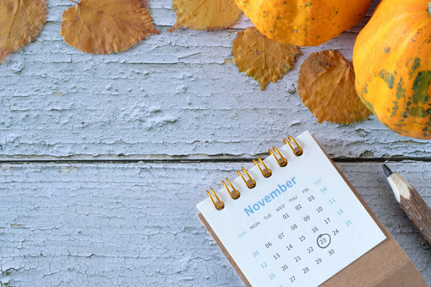 23 de noviembre fecha en calendario con hojas de otoño y calabaza sobre fondo de madera. Concepto del día de Acción de Gracias. Vista superior, espacio de copia. - Foto, imagen