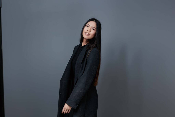 Roztomilý žena zimní asijské trendy šedé oblečení krása studio portrét kabát podzim módní vlasy krásný model úsměv půvab dívka podzim životní styl bruneta - Fotografie, Obrázek