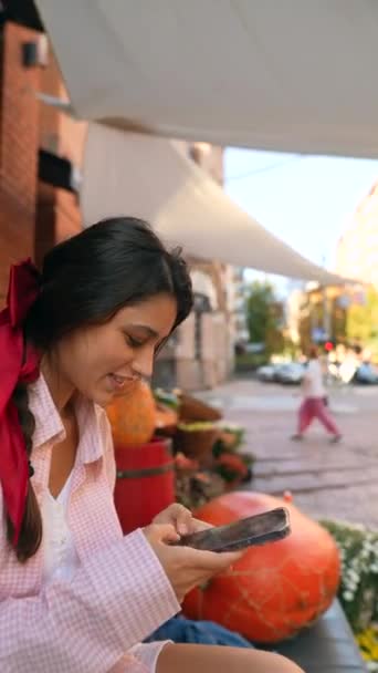 Prodejce na farmářském trhu, půvabná mladá žena v růžovém, vybavená chytrým telefonem. Vysoce kvalitní 4K záběry - Záběry, video