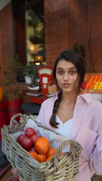 "ευρωπαϊκή αγορά αγροτών υπερηφανεύεται για μια όμορφη νεαρή γυναίκα που νοιάζεται για το περιβάλλον, καθώς οργανώνει τα λαχανικά σε ένα καλάθι. Υψηλής ποιότητας 4k πλάνα - Πλάνα, βίντεο