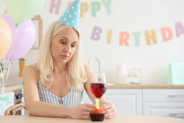 Traurige reife Frau feiert Geburtstag in Küche - Foto, Bild