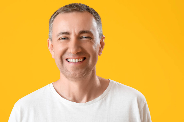 Portré boldog érett férfi narancssárga háttér - Fotó, kép